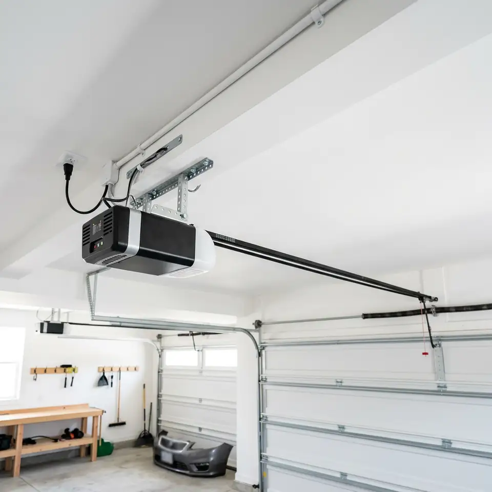 Newly mounted belt drive garage door opener and rail on a garage ceiling